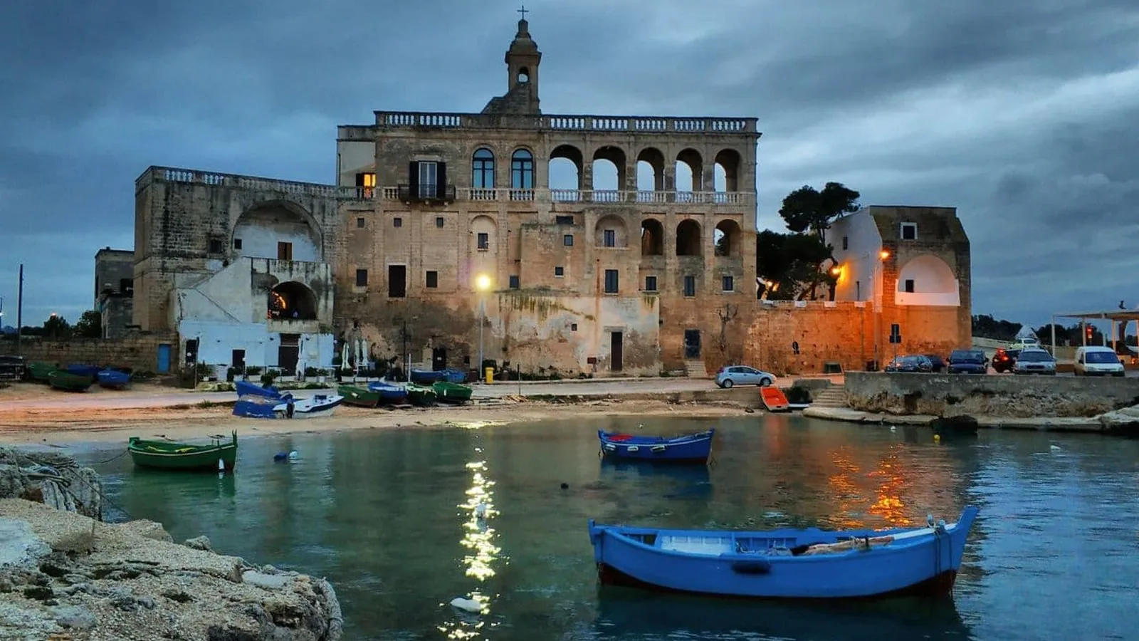 L'Abbazia di San Vito al crepuscolo, con le barche da pesca nel porticciolo